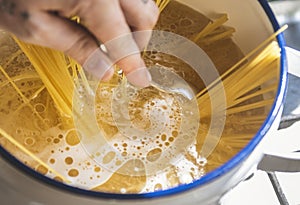 A chef boiling capellini pasta in the pot