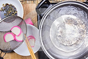 Chef boiling kamaboko fish cake in pot