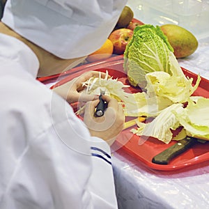 Chef carves patterns on cabbage and other vegetables and fruits for a beautiful table decoration