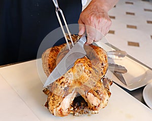 A chef carving roast turkey in a live display