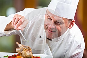 Chef. Chef cooking.Chef decorating dish. Chef preparing a meal. Chef in hotel or restaurant kitchen prepares decorating dish with