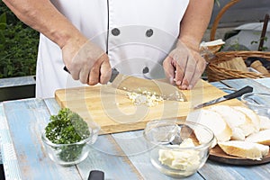 Chef chopping garlic for cooked Garlic bread