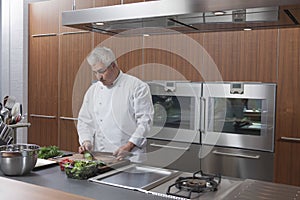 Chef Chopping Vegetables In Commercial Kitchen