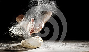 Chef clapping his hands to dust dough with flour