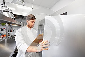 Chef with clipboard doing inventory at kitchen