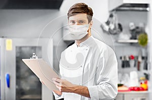 Chef with clipboard in face mask at restaurant