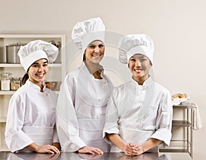 Chef co-workers posing in commercial kitchen