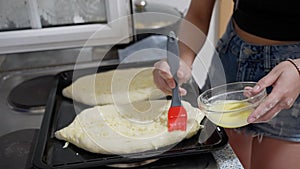 The chef coats Georgian cheese khachapuri dough with a liquid egg
