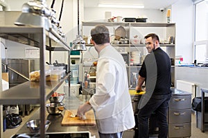 Chef and cook cooking food at restaurant kitchen