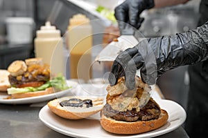 Chef cooking burger,close-up, making sandwich, fast food concept, recipe of preparing homemade hamburger with vegetables