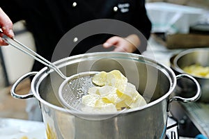 Chef cooking delicious french fries in a pot