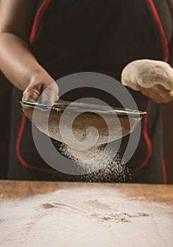 Chef cooking dough to bake a cake on a wooden table.