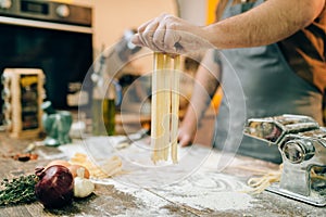 Chef cooking fettuccine in pasta machine