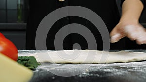 Chef is cooking italian pizza. Making and preparing dough for homemade bakery. Process of making pizza at table . Fresh dough on k