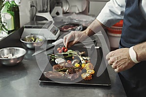 Chef cooking juicy beef steak at restaurant kitchen