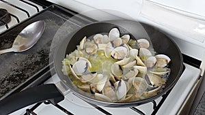 Chef cooking mussels cooking in pan. Chef frying mussels on pan, steaming mussels