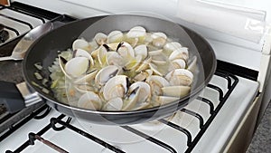 Chef cooking mussels cooking in pan. Chef frying mussels on pan, steaming mussels