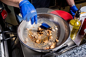 Chef cooking pasta with mussels in pan. Italian style cuisine. Restaurant.