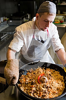 Chef cooking plov traditional uzbek rice meal