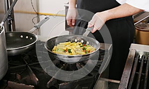 Chef cooking rigatoni with vegetables