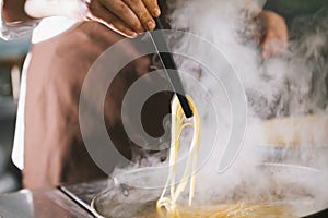 Chef cooking spaghetti in restaurant
