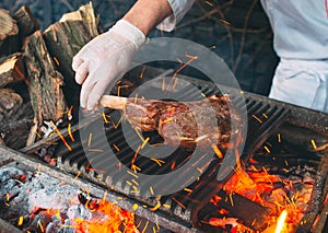 Chef Cooking steak. Cook turns the meat on the fire.