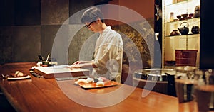 Chef, cooking and sushi in kitchen of restaurant for traditional food, cuisine or gourmet dish. Luxury, catering and