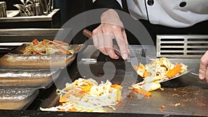 Chef cooking teppanyaki vegetable steak on hot plate