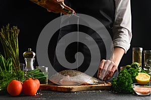 Chef cooks fish, pouring oil, Freezing in motion, seafood, gastronomy, sale of fresh fish, fish market. Homemade Fish Recipes