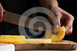 The chef cooks pizza, cut pineapple, on the background with ingredients. Recipe book, menu, home cooking