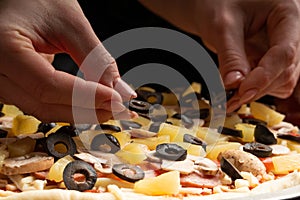 Chef cooks pizza, puts olives on the background with ingredients. Recipe book, menu, home cooking, pizzeria. Macro, close-up