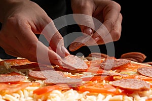 The chef cooks pizza, spreads salami on the background with ingredients. Recipe book, menu, home cooking. Close up macro