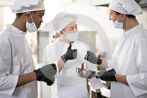 Chef cooks tasting sauce with a spoon while cooking in the kitchen