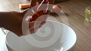 Chef cracking an egg in a bowl and separating egg white from yolk