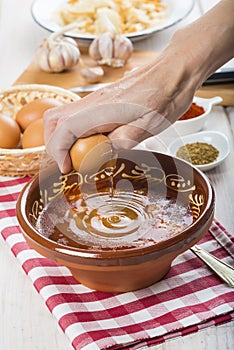 Chef cracking an egg on a garlic soup