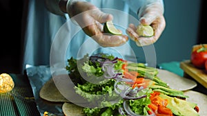 The chef crushes lime to get juice over the burrito