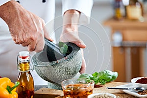 Chef crushing a blending fresh herbs