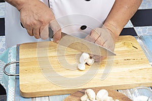 Chef cut mushrooms with a knife