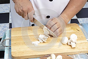 Chef cut mushrooms with a knife