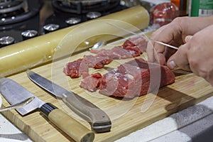 Chef cut up red meat beef fillet on wooden board