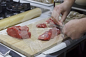 Chef cut up red meat beef fillet on wooden board