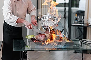 Chef cuts baked Turkey on a platter in the fire. Roast Turkey.