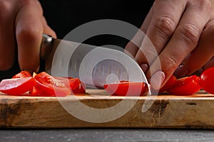 The chef cuts cherry tomatoes to prepare a tasty and fresh salad. Vegetarian and fresh food, gastronomy and cooking, recipe book