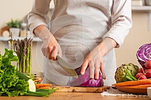 The chef cuts, chops fresh purple lettuce salad. The concept of losing healthy and wholesome food, detox, vegan eating, diet,