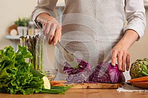 The chef cuts, chops fresh purple lettuce salad. The concept of losing healthy and wholesome food, detox, vegan eating, diet,