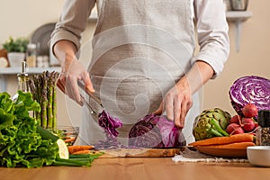 The chef cuts, chops fresh purple lettuce salad. The concept of losing healthy and wholesome food, detox, vegan eating, diet,