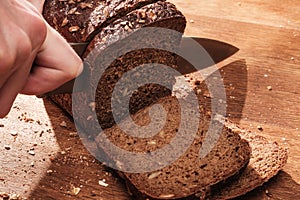 Chef cuts with a knife Whole Fresh fragrant bread on table. Food concept Wheat pastry on cutting board