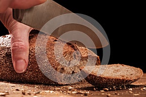 Chef cuts whole Fresh fragrant bread on table. Food concept Wheat pastry on cutting board