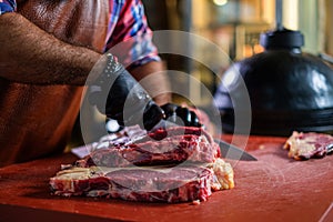 Chef cutting beef steakes in a restaurant