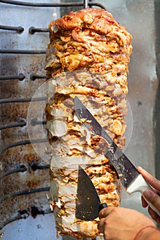 Chef cutting with doner knife Traditional Turkish Doner Kebab meat